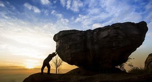 bigstock-Man-pushing-a-boulder-on-a-mou-56958671.jpg